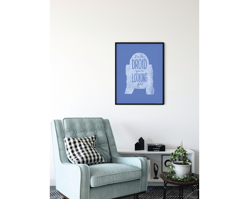 Dekorativt rum med fåtölj och inramad Star Wars-affisch med texten Jag är droiden du letar efter.
