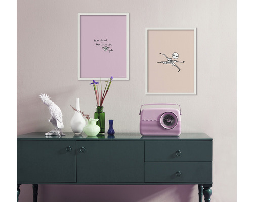 Dekorativ inredning med skänk, två inramade bilder och en radio