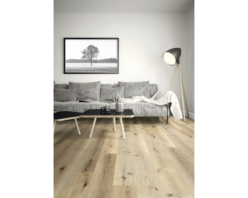 Vardagsrum med ljust trägolv, soffa, bord och golvlampa