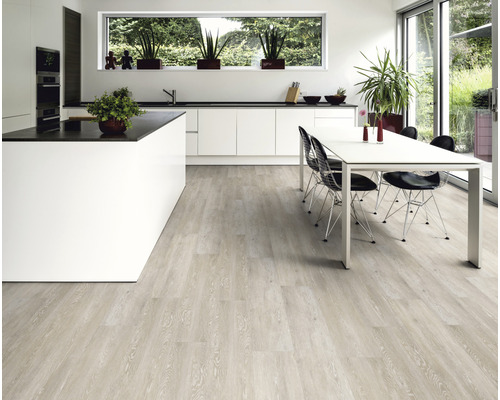 Ljust trägolv i ett modernt kök med köksö och matbord.