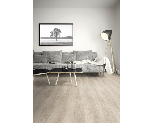 Ljust vardagsrum med laminatgolv, soffa, bord och golvlampa