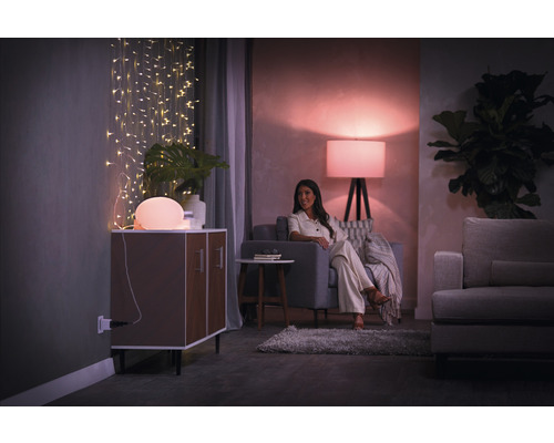 Vardagsrum med belysning, byrå, soffa och kvinna