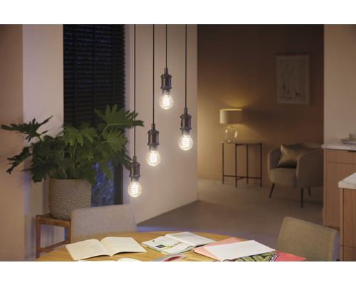 Fyra hängande glödlampor ovanför ett matbord i ett rum