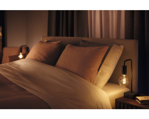 Sovrum med säng, kuddar och bordslampa