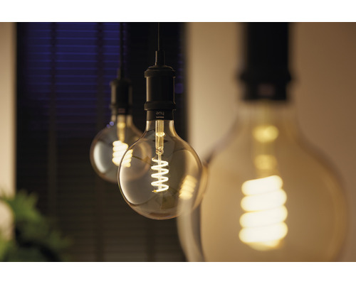 Tre glödlampor med glödtrådar hänger från taket