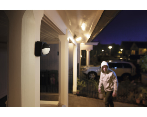 Exteriör av ett hus med en rörelsesensorlampa som lyser upp en inbrottstjuv.
