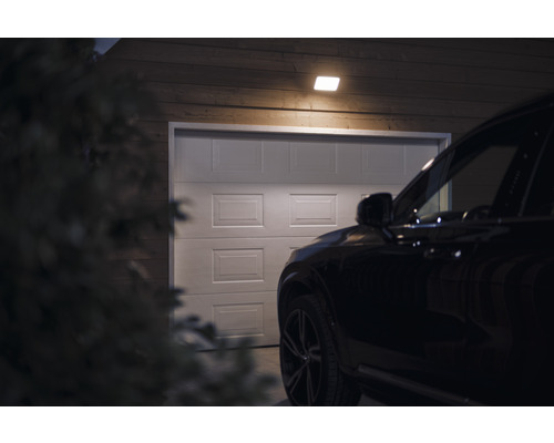 Garage med belysning och bil framför