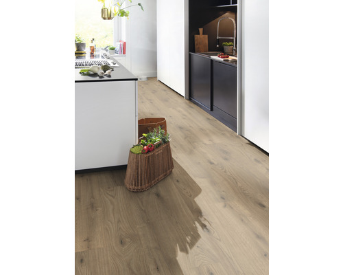 Ljust kök med laminatgolv i trälook och korg med grönsaker