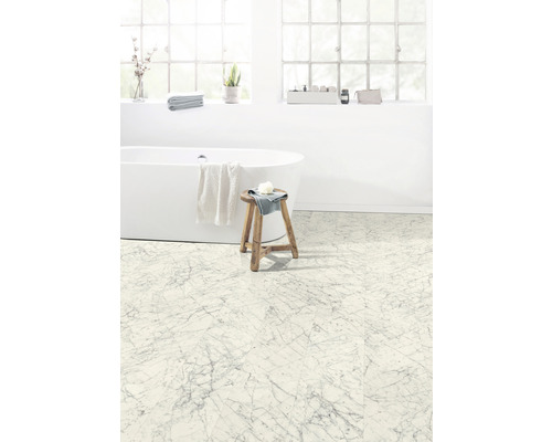 Ljust badrum med badkar och golvplattor i marmorlook