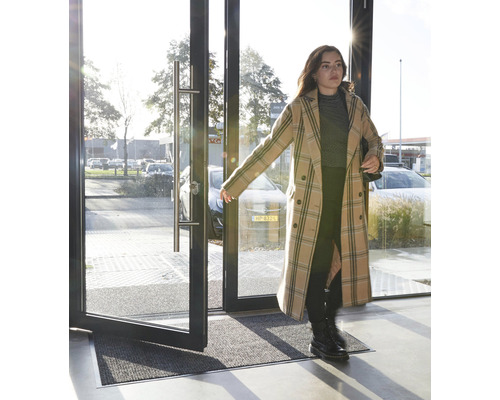 Entré med avtorkningsmatta framför en öppningsbar glasdörr