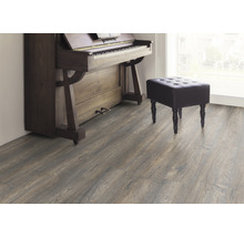 Interiör med laminatgolv, piano och pall
