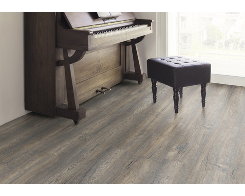 Interiör med laminatgolv, piano och pall