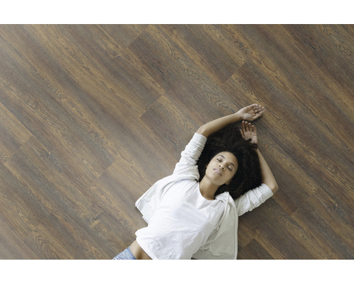 Kvinna ligger på laminatgolv med träutseende
