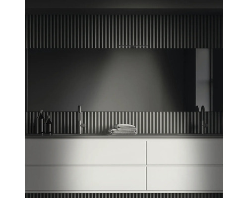 Modernt badrum med tvättställsskåp, spegel och handdukar