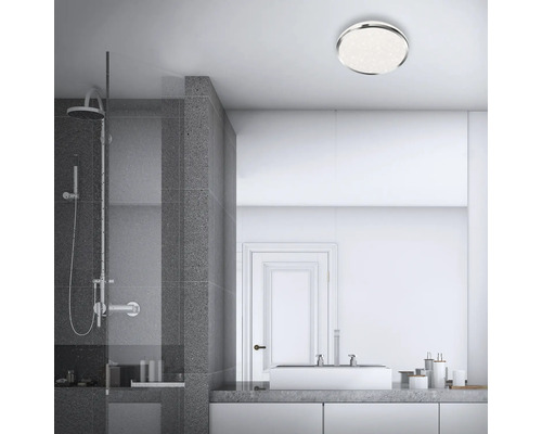 Modernt badrum med dusch, handfat och rund taklampa