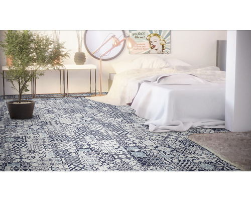 Sovrum med säng och vinylgolv i patchworkdesign.