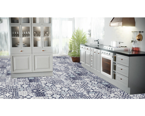 Ljust kök med köksskåp, spis och golv med mönster