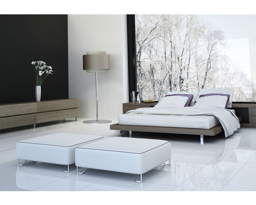 Modernt sovrum med dubbelsäng, nattduksbord, byrå, golvlampa och pallar