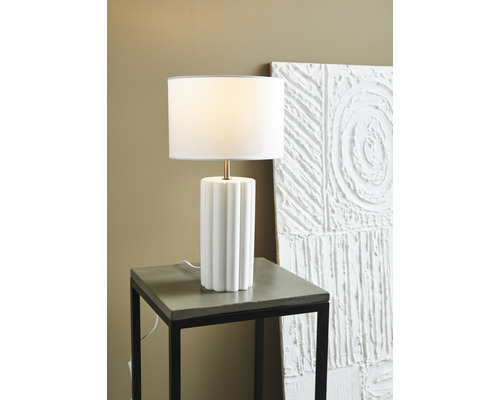 Bordslampa med tygskärm på ett sidobord