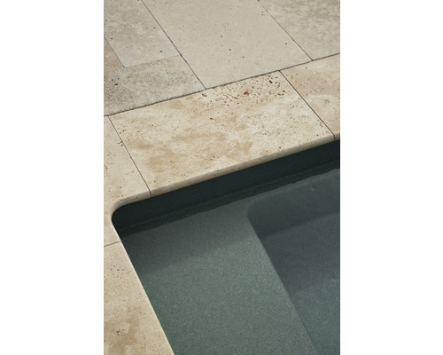 Detaljbild av en pool med travertinkant