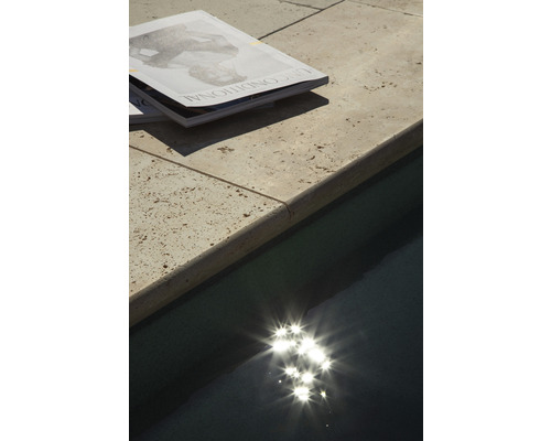 Tidskrifter på en poolkant bredvid en pool