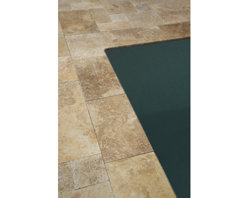 Detalj av ett trädgårdsdäck av travertin bredvid en pool