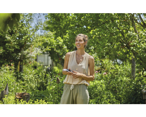 Kvinna med trädgårdssax i trädgården