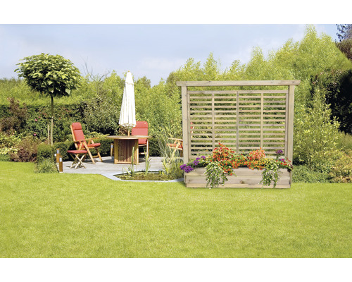 Trädgård med insynsskydd i trä, blomlåda och sittgrupp på gräsmatta
