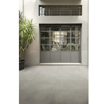 Miljö med grå golvplattor och ett fönster med stålram