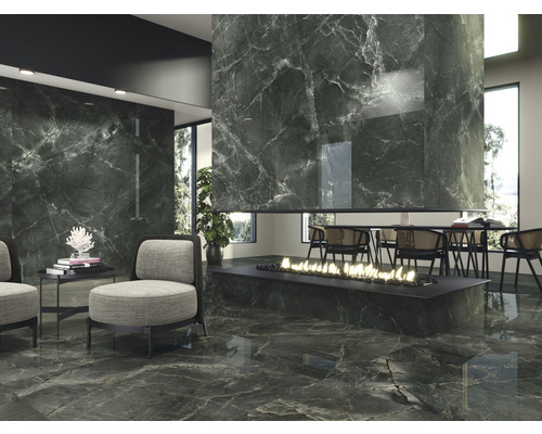 Ett vardagsrum med golvplattor och väggplattor i marmordesign, en öppen spis och sittplatser skapar en elegant atmosfär.