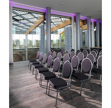 Interiör med stolsrader, trägolv och fönsterparti