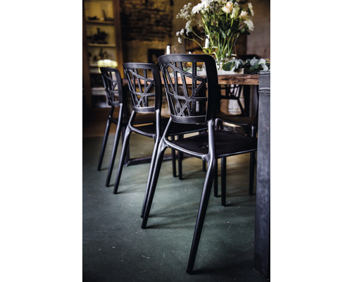 Svart stol med öppen ryggdesign vid ett matbord