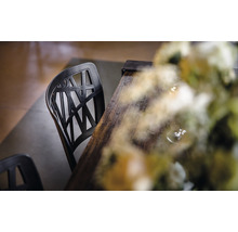 Svart plaststol med träbord och blomdekoration