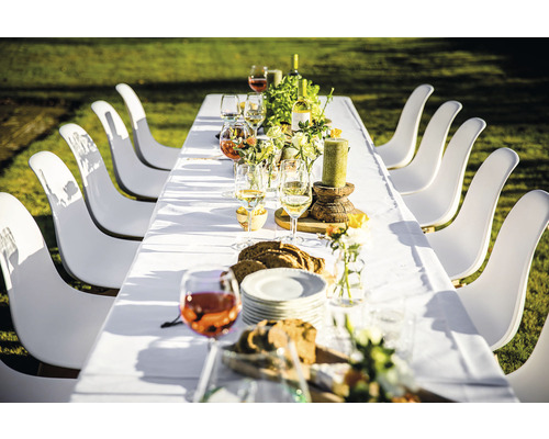 Dukat matbord med vita stolar utomhus