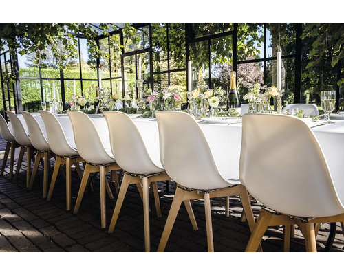Festligt dukat bord med stolar för ett utomhusevenemang.