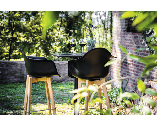 Utomhusscen med två barstolar och ett bord med vinglas och lavendel