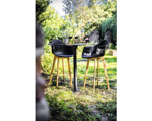 Trädgårdsscen med bistrobord och två barstolar utomhus