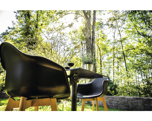 Trädgårdsscen med bord, två stolar, två glas vin och en växt