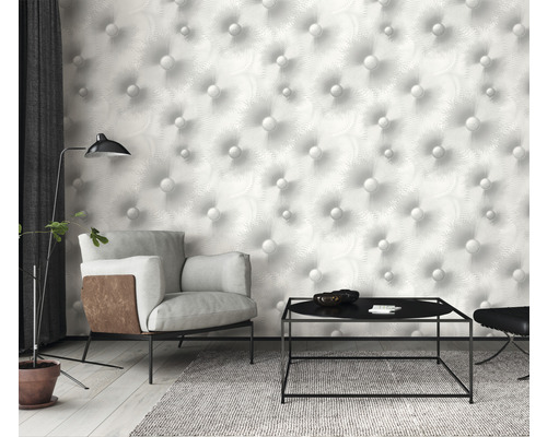 Vardagsrum med fåtölj, bord och tapet med knappmönster