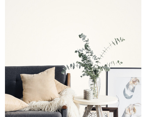 Vardagsrum med grå soffa, kuddar, sidobord, vas med eukalyptus och fotoramar.