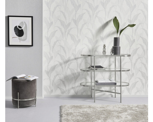 Vardagsrum med mönstrad tapet, pall, bord och dekoration