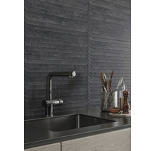 Köksscen med diskho, blandare och väggplattor med vågmönster