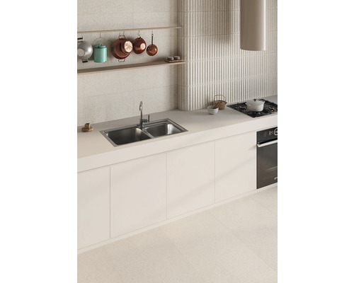 Köksscen med diskho, spis och köksredskap på väggen