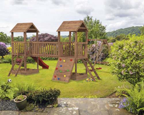 Lekplats för barn i trä med gunga, rutschkana och klättervägg i trädgården.