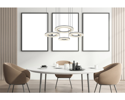 Matsal med matbord, stolar, pendellampa och tre inramade bilder