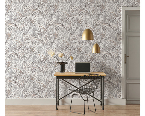 Kontor med skrivbord, stol, bärbar dator, gyllene lampor och tapet med växtmönster