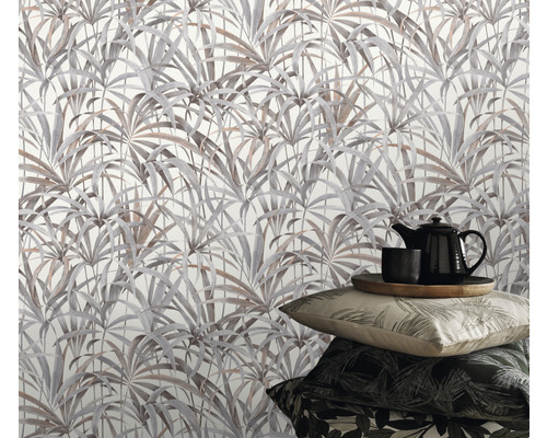 Miljöbild med tapet med bladmotiv, tekanna och kuddar