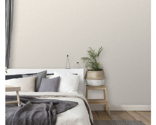 Sovrum med säng, kuddar, filt, krukväxt och sängbord