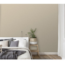 Sovrum med säng, krukväxt och enfärgad tapet