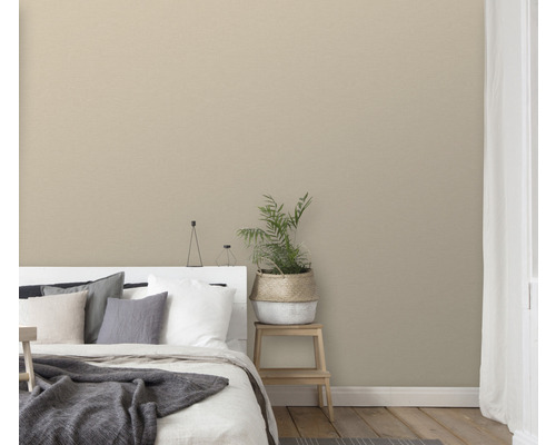 Sovrum med säng, krukväxt och enfärgad tapet